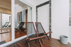 two chairs sitting on a porch with a balcony at Azores Inn - Family Suites in Ponta Delgada