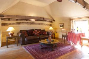 - un salon avec un canapé et une table dans l'établissement Mill Cottage set beside a Mill pond in a 70 acre Nature Reserve Bliss, à Assington