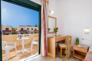 a room with a balcony with a table and chairs at Kambos Village in Agia Marina Nea Kydonias