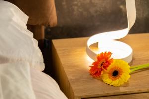eine Blume auf einem Nachttisch mit einer Lampe in der Unterkunft Eutuxia in Taranto