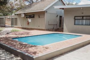 a swimming pool in front of a house at Casa Leitao Lodge in Phalaborwa
