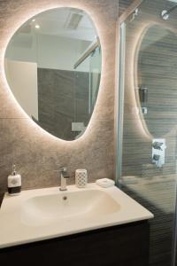 ein Bad mit einem Waschbecken und einem Spiegel in der Unterkunft Eutuxia in Taranto