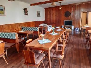 une salle à manger avec des tables et des chaises en bois dans l'établissement Pension Paulů, à Pec pod Sněžkou