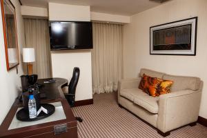 a living room with a couch and a chair in a hotel room at Eurobuilding Express Barinas in Barinas