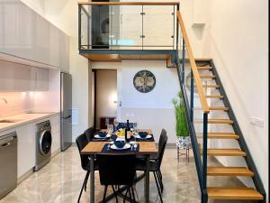a dining room with a table and chairs and a staircase at Tr3 aparcamiento incluido familias loft almirante in Seville