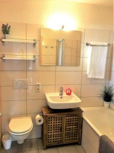 ジールクスドルフにあるHygge-skandinavisch-mit-Kamin-und-Saunaのバスルーム(洗面台、トイレ、バスタブ付)