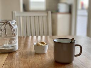 une tasse de café et un pot de nourriture sur une table dans l'établissement Hygge-skandinavisch-mit-Kamin-und-Sauna, à Sierksdorf
