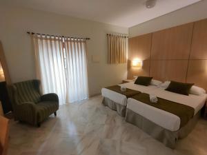 
a hotel room with a large bed and a large window at Hotel Boutique Convento Cádiz in Cádiz
