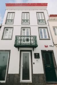 a white building with a balcony and a door at Azores Inn - Family Suites in Ponta Delgada