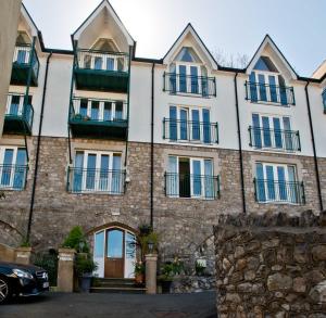 un edificio de apartamentos con balcones y un coche aparcado enfrente en Patricks Boathouse, en Swansea