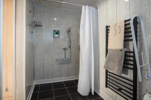 a shower with a shower curtain in a bathroom at Estuary Lodge Motel B&B in Talsarnau +47 photos