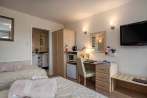 a hotel room with a bed and a desk and a kitchen at Estuary Lodge Motel in Talsarnau
