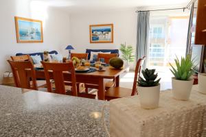 uma sala de jantar e sala de estar com mesa e cadeiras em Rocha Beach Flat by ALgest em Portimão
