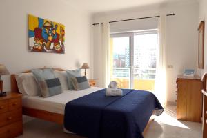 um quarto com uma cama com um cobertor azul em Rocha Beach Flat by ALgest em Portimão