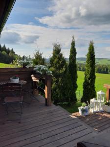 una terrazza in legno con tavolo e sedie. di domek w Krynicy Zdroju a Krynica-Zdrój