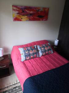 a bedroom with a pink bed with pillows on it at Departamento Pucón Nativo in Pucón