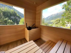 un sauna avec une grande fenêtre et un banc dans l'établissement Das Schider - Boutique Apart-Hotel, à Bad Gastein
