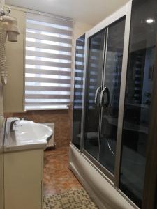 a bathroom with a glass shower and a sink at Prometey Hotel in Kamianske