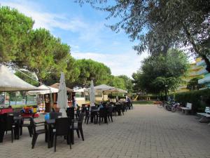 een groep tafels en stoelen met parasols bij Appartamenti Valbella in Bibione