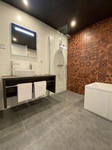 a bathroom with a sink and a shower and a mirror at Fletcher Hotel-Restaurant ByZoo Emmen in Emmen