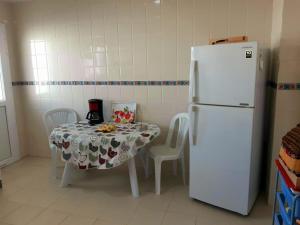 a kitchen with a table and a white refrigerator at Perle de Gammarth in Gammarth