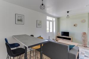 sala de estar con mesa y sofá en cosy cottage proche gare en Vannes