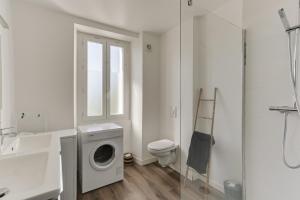 baño blanco con lavadora y lavamanos en cosy cottage proche gare en Vannes