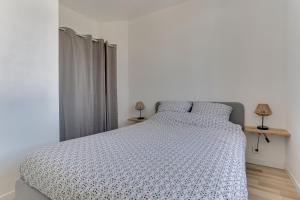 1 dormitorio con 1 cama blanca y 2 almohadas en cosy cottage proche gare en Vannes