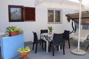 patio ze stołem, krzesłami i parasolem w obiekcie Holiday apartment in Tribunj with terrace, air conditioning, W-LAN 5034-1 w mieście Tribunj