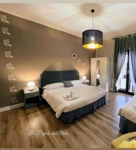 - une chambre avec un grand lit blanc et un lustre dans l'établissement La Pigna dell'Etna, à Nicolosi