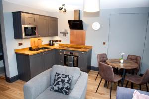 cocina y sala de estar con sofá y mesa en Little Elm - luxury home from home, free parking, 30-40 mins walk from Bath city centre en Bath