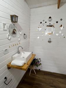 uma casa de banho com um lavatório e corações na parede em Vila Velasco em Campos do Jordão