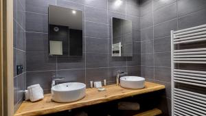 Un baño con dos lavabos y un espejo. en Chalet Juliette by Les Etincelles, en Belle Plagne 18 fotos más
