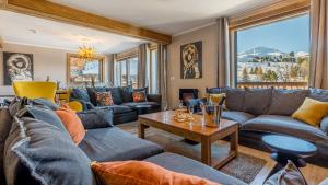 Una sala de estar con sofás y una mesa. en Chalet Juliette by Les Etincelles, en Belle Plagne