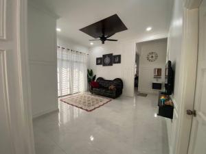 sala de estar con sofá y ventilador de techo en ADDA Guest House, en Kota Bharu
