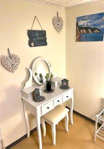 a white dressing table with a mirror and a chair at Ferienwohnung Vogel in Selbitz