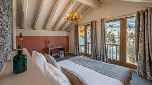 Un dormitorio con una cama y una ventana grande. en Chalet Violette by Les Etincelles, en La Plagne