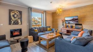 sala de estar con sofás azules y chimenea en Chalet Violette by Les Etincelles, en La Plagne