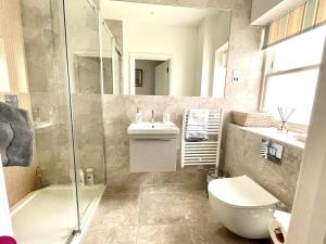 ein Bad mit einem WC, einem Waschbecken und einer Dusche in der Unterkunft Beachfront with balcony 1st Floor apartment "The Beaches" in Weymouth