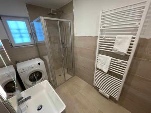 bagno con lavatrice e lavandino di Ferienhaus Marchhäuser 12 a Haidmühle