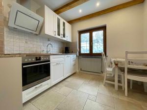 a kitchen with white cabinets and a table and a microwave at Ferienhaus Marchhäuser 12 in Haidmühle