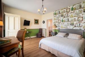 a bedroom with a bed and a desk and a piano at Chambres d'Hôtes Les Champs Français in Caumont-lʼÉventé