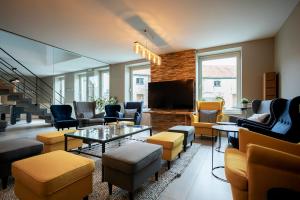 a living room with couches and chairs and a flat screen tv at Enjoytoday vakantiewoning 45 in Oudenaarde