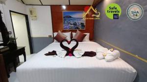 a bedroom with a bed with two stuffed animals on it at Beach Home Lanta in Ko Lanta