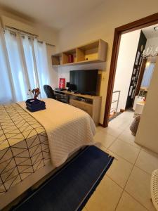 a bedroom with a bed and a flat screen tv at Cabo Frio Familiar Toca de Gente Feliz in Cabo Frio