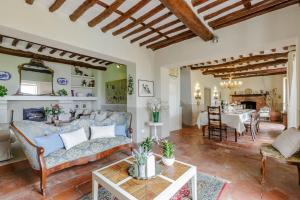a living room with a couch and a table at Melograno Farmhouse, ROMANTIC FARMHOUSE VILLA WITH PRIVATE INFINITY POOL AND GREAT VIEWS IN LUCCA in Piaggiori