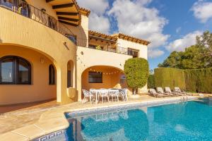 een villa met een zwembad en een huis bij Villa Mandarina - Costa CarpeDiem in Calpe