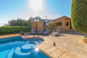 a swimming pool in a yard with chairs and a house at Villa Mandarina - Costa CarpeDiem in Calpe