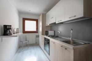 a kitchen with a sink and a stove top oven at Canaletto Apartment Rialto in Venice