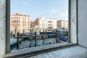 een uitzicht vanuit een raam op een kanaal met boten bij Canaletto Apartment Rialto in Venetië